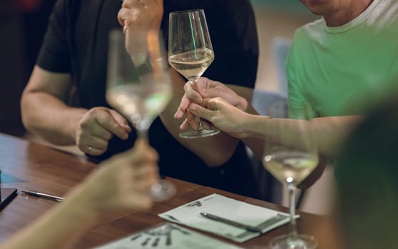 A group of people sitting at a table with wine glasses