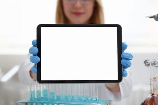 A female doctor in a chemical laboratory holds a tablet in his hand with display, you can insert a picture or an image you want to write for an advertising company