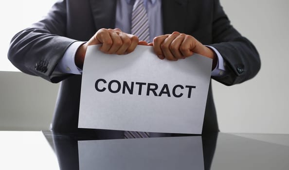White collar worker in suit and tie tear contract closeup. Get jobless arm form rip job loss customer offer human resources staff reduction service failure legal trouble attitude concept