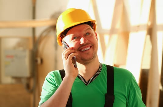 Carpenter talking on phone in hardware store furniture manufacturing takes an order