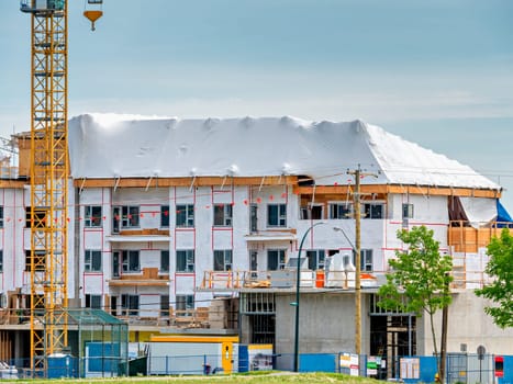 New low-rise residential building under construction on blue sky background.