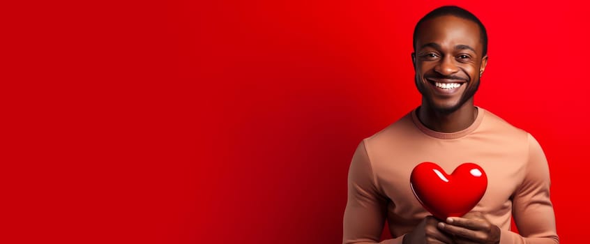 Happy, elegant, laughing, carefree man African American black guy with heart on red background for Valentine's day, banner, advertisement. Valentine's day, newlyweds, engagement, holiday, birthday, wedding, anniversary, surprise, date.