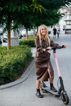 Blonde with an electric scooter in the park for a walk