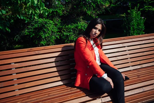 brunette woman sitting on a park bench for a walk