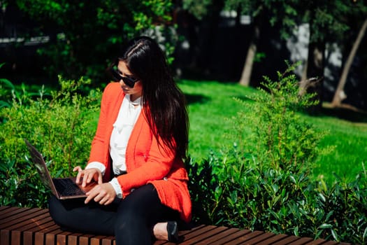 Woman with laptop working on a park