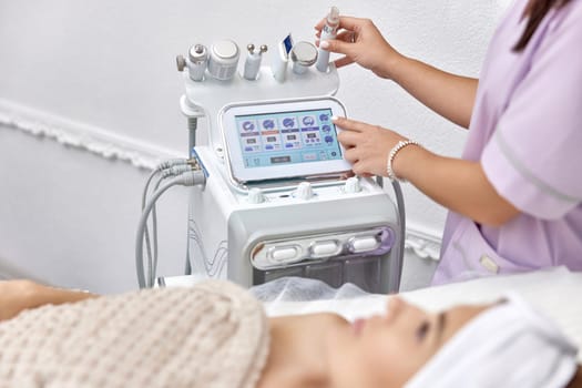 beautician using cosmetology equipment in modern aesthetic clinic.
