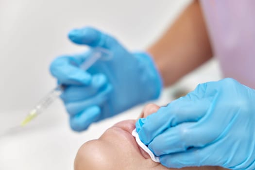 cosmetologist makes injections to enlarge the lips of beautiful woman. procedure lip augmentation