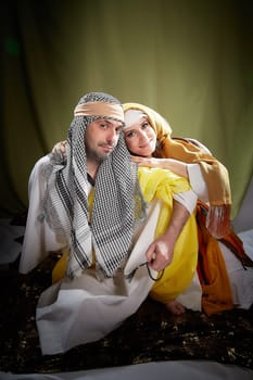 A couple in love or a married couple in stylized Eastern clothing from Israel, Palestine, Iran, Pakistan together. Tender photo session in the style of the Middle East and the Bible