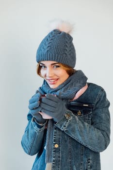 Beautiful woman in winter hat and warm clothes drinking hot tea