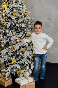 Boy at christmas tree gifts and toys