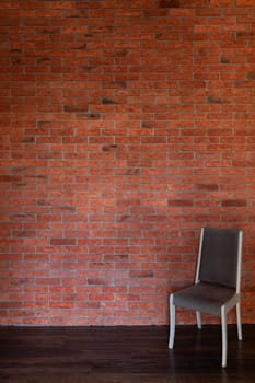 vintage chair against an old brick wall in the interior