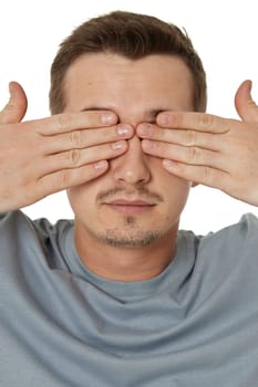 man covering eyes with hands on white background