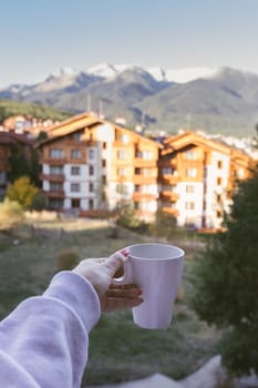 a cup of tea against the backdrop of the hotel and beautiful mountains in Bansko, Bulgaria.