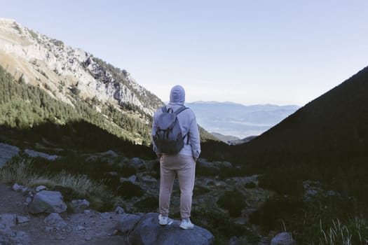 A tourist stands on the peak of a mountain