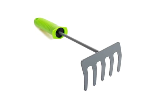 Small garden rake with green plastic handle isolated on a white background.