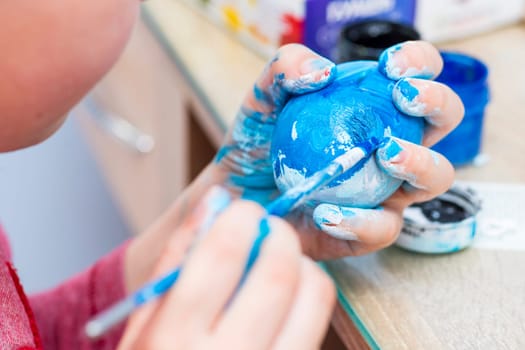 Happy easter. A boy painting Easter eggs at home. A child preparing the easter eggs for Easter.