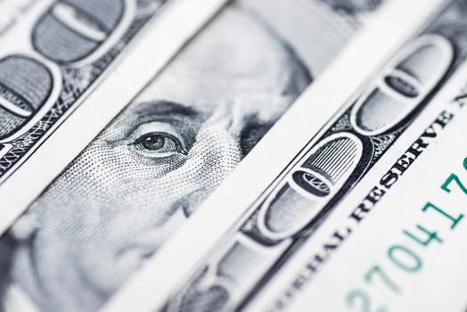 Benjamin Franklin's eyes from a hundred-dollar bill. The face of Benjamin Franklin on the hundred dollar banknote, backgrounds, close-up. 100 dollar bill with only eyes of Benjamin Franklin