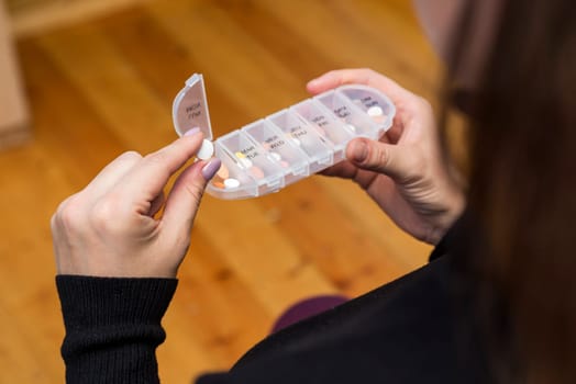 Woman taking medication from pill box. Health care, vitamins and treatment concept.