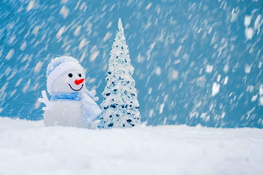 Happy snowman with Christmas tree in winter scenery with copy space. Christmas background with snowman.
