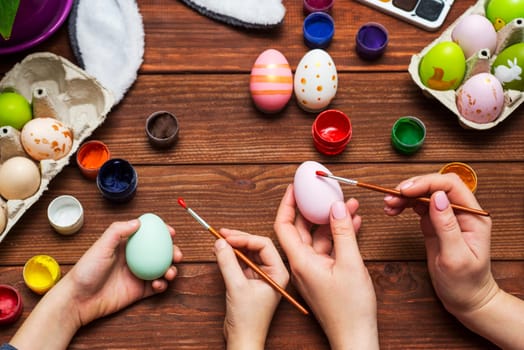 Mother and son are painting Easter eggs. Preparing decorations for Easter, creativity with children, traditional symbols. Preparing for Easter.