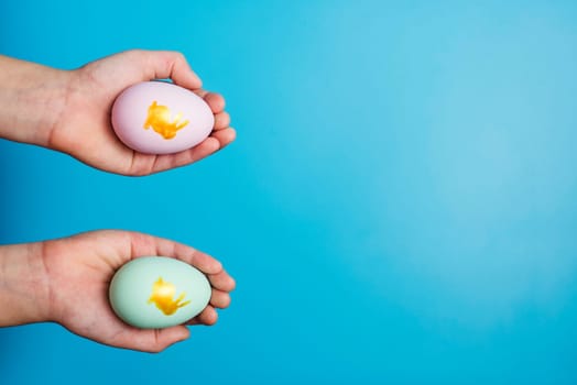 Hands holding painted easter eggs. Easter eggs in a childs hands on a blue background.
