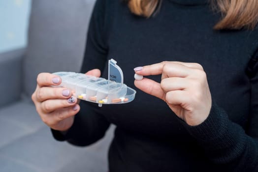 Woman taking medication from pill box. Health care, vitamins and treatment concept.