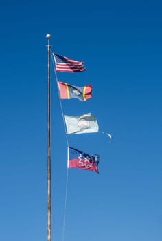 Flagpole with USA and Mississippi state flags, Greenville City flag and Juneteenth Flag in the town in Mississippi