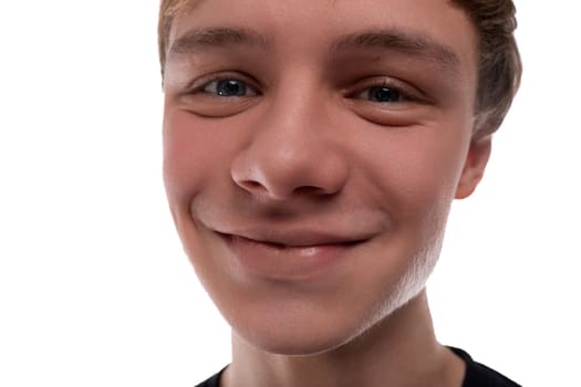 Caucasian blond 16 year old guy dressed in a black T-shirt close-up, cute smile.