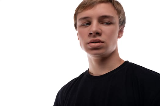 Cute fair-haired teenager guy on a white background, close-up portrait.