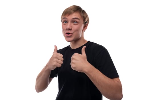 Portrait of a positive smiling blond teenager guy in a black T-shirt.