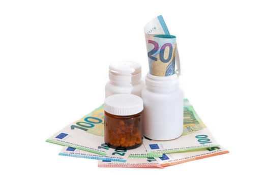 Different Bottles with Pills, Capsules and Medicines on the Euro Banknotes - Isolated on White. Global Pharmaceutical Industry and Big Pharma. Euro Money Bills - Isolation