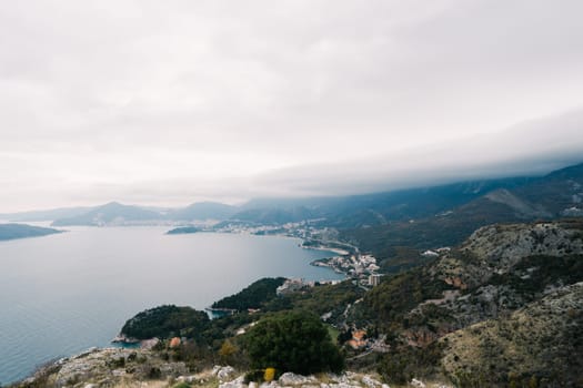 Bay surrounded by high green mountains in fog. High quality photo