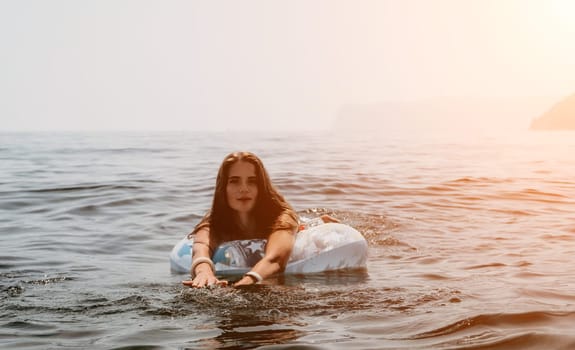 Woman summer sea. Happy woman swimming with inflatable donut on the beach in summer sunny day, surrounded by volcanic mountains. Summer vacation concept