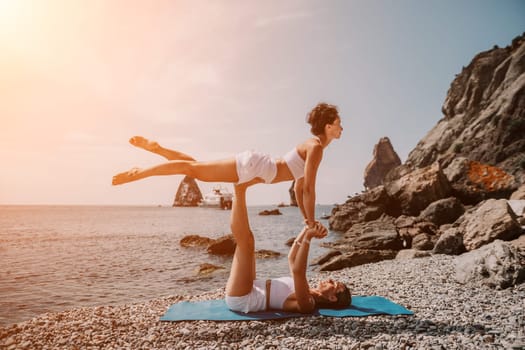 Woman sea yoga. Back view of free calm happy satisfied woman with long hair standing on top rock with yoga position against of sky by the sea. Healthy lifestyle outdoors in nature, fitness concept.