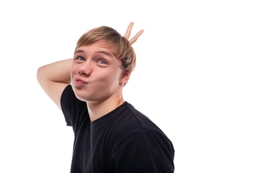 Funny teenage guy with blond hair makes a grimace.