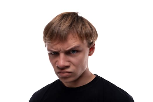 Offended teenage guy with blond hair dressed in a black T-shirt.