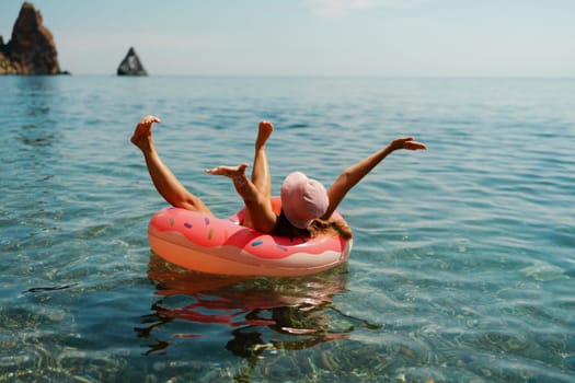 Summer vacation woman in hat floats on an inflatable donut mattress. Happy woman relaxing and enjoying family summer travel holidays travel on the sea