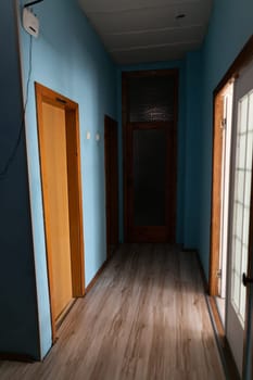 Dark corridor with doors in the apartment blue