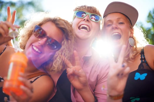 Portrait, peace sign and funny friends in sunglasses outdoor, blowing bubbles and laughing together in summer. Face, women and group of girls with v hand gesture, excited and lens flare in nature.