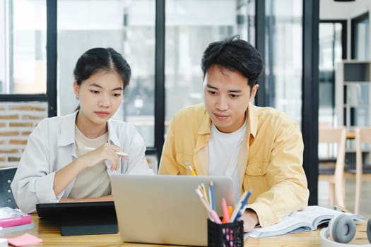 Learning, education and school concept. Young woman and man studying for a test or an exam. Tutor books with friends. Young students campus helps friend catching up and learning.