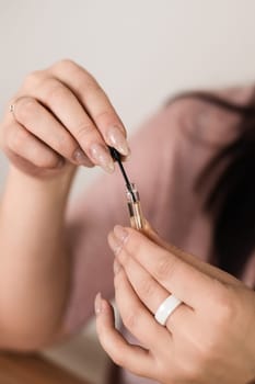 Women's hands hold a small perfume sample close-up in the room