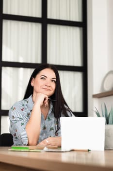 The brunette girl was thinking while sitting at her desk in the office