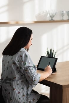 The girl in the office is working with a phone and tablet