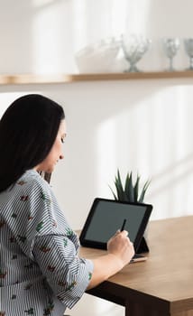 The girl is working at a table with gadgets