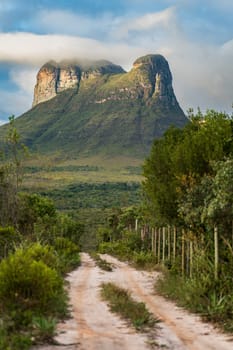 A dirt path in Africa leads to a rocky outcrop, showcasing the unique landscape of the Diamantina plateau.