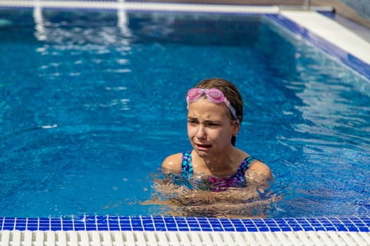 A child is crying in the pool. Selective focus. Kid.