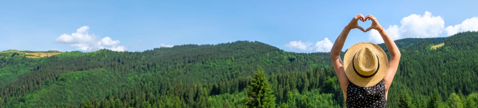 A woman in the mountains admires nature. Selective focus. Nature.