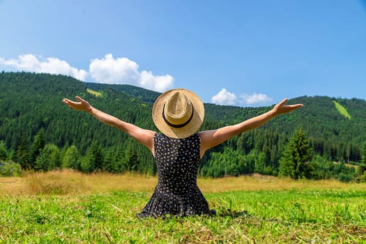 A woman in the mountains admires nature. Selective focus. Nature.