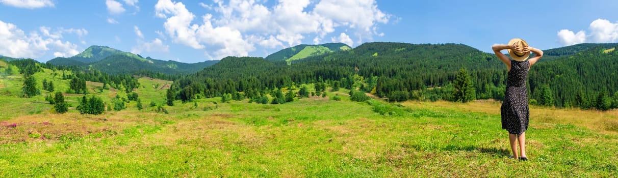 A woman in the mountains admires nature. Selective focus. Nature.