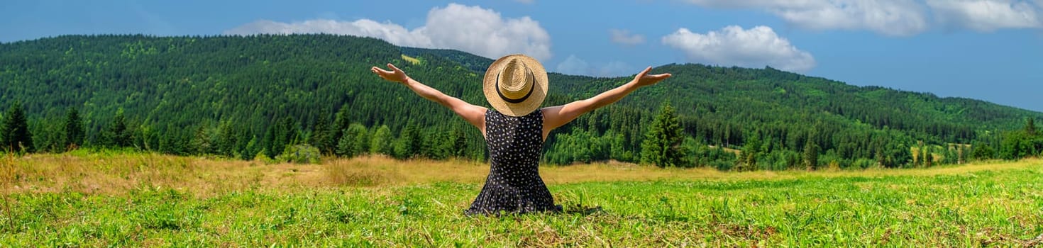 A woman in the mountains admires nature. Selective focus. Nature.